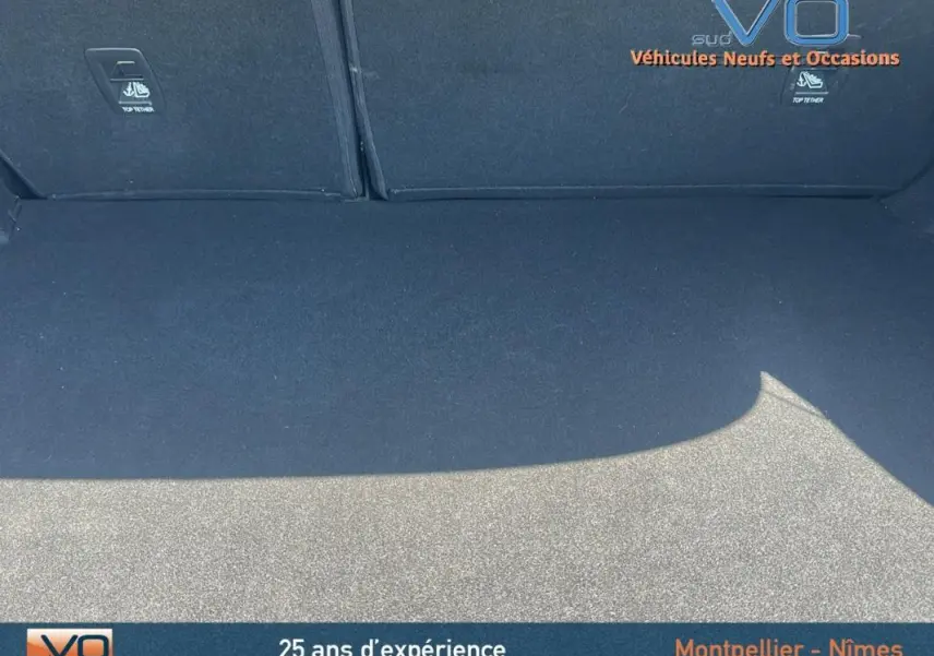 Coffre spacieux et propre de la Renault Mégane IV Berline gris, vue intérieure arrière avec sièges rabattables visibles.