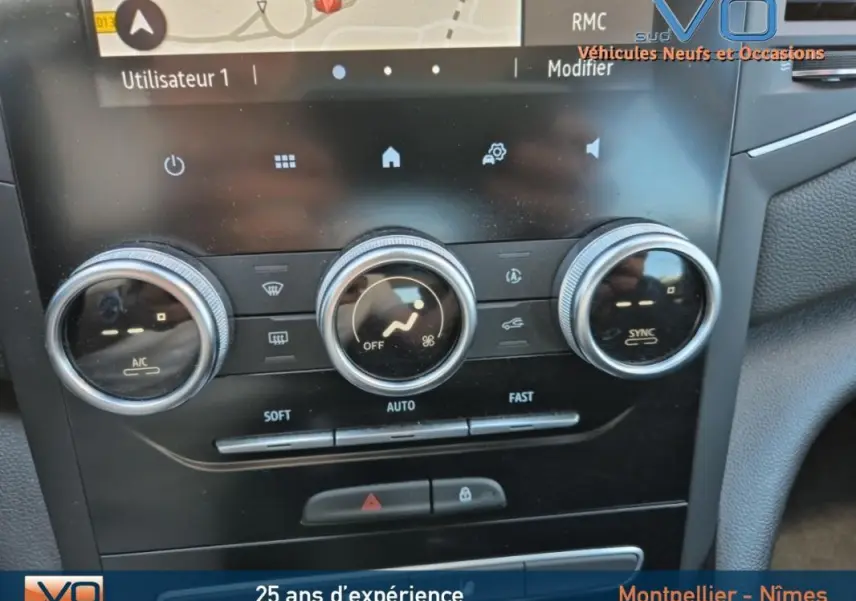Gros plan sur la console centrale de la Renault Mégane IV Business 2020, montrant les commandes de climatisation automatique et l'écran tactile.