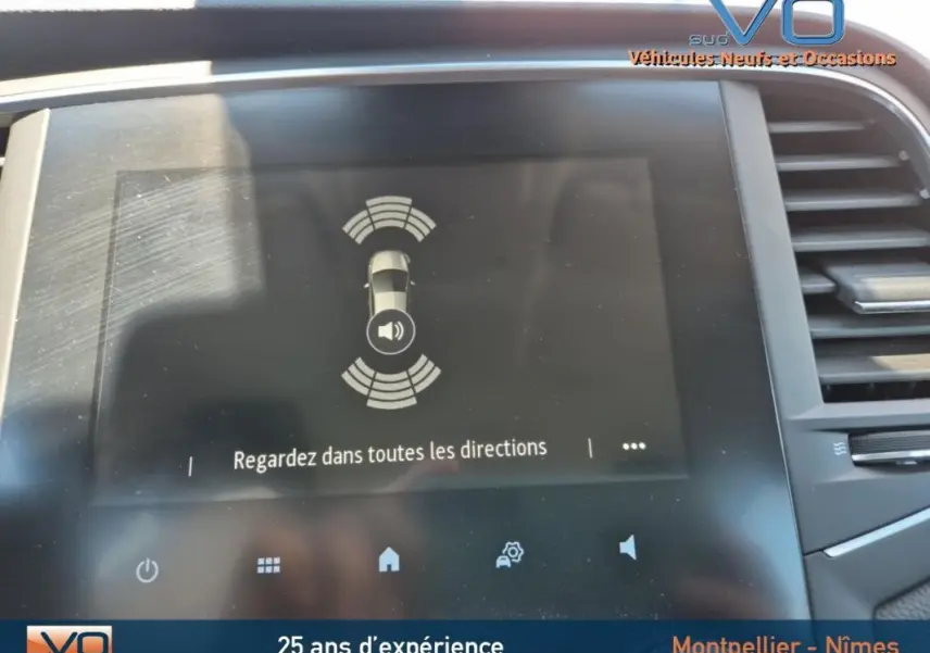 Écran tactile du système d'aide au stationnement de la Renault Mégane IV Business, intérieur moderne gris.