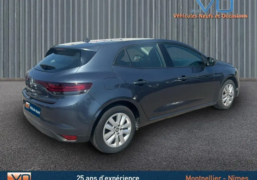 Vue 3/4 arrière droite d'une Renault Mégane IV grise, berline compacte avec jantes 16 pouces et feux arrière LED.