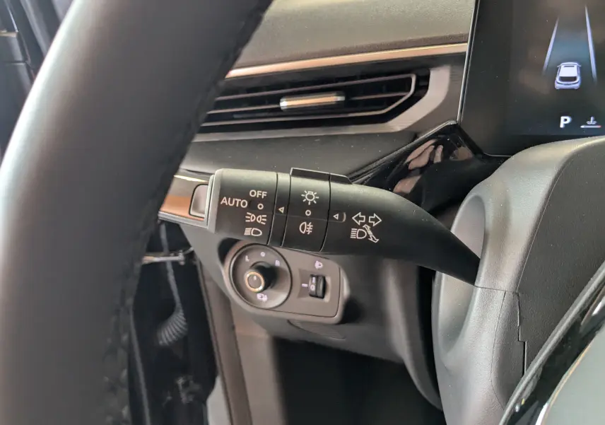 Gros plan sur la commande des feux et clignotants côté gauche du tableau de bord noir du MG3 1,5 HYBRID+ 195cv Luxury 2026.
