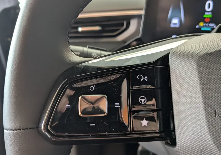 Gros plan sur les commandes noires à gauche du volant du MG3 1,5 HYBRID+ 195cv Luxury en Pebble Black, 2026.