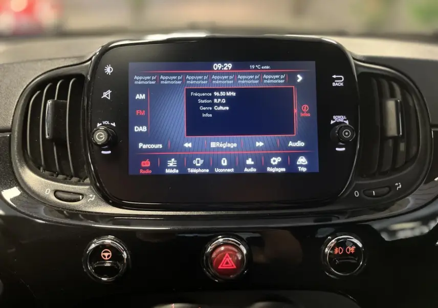 Écran tactile central allumé du tableau de bord noir brillant de la Fiat 500 Dolcevita 2023, vue frontale rapprochée.