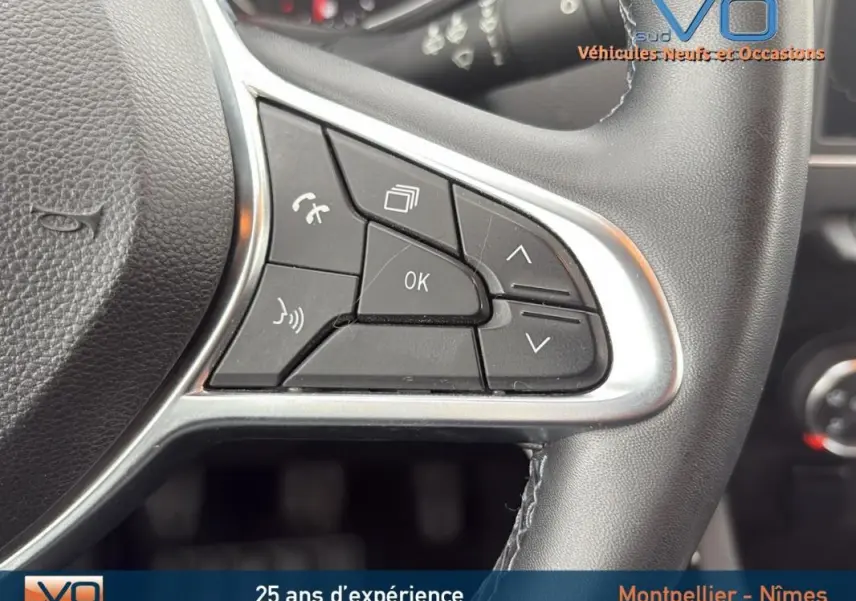 Gros plan sur les commandes multifonctions à droite du volant d'une Renault Clio gris foncé, version Business 2020.