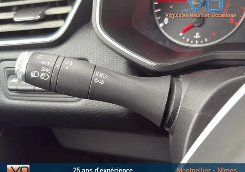 Gros plan sur la commande des feux et clignotants dans l'habitacle d'une Renault Clio gris foncé, version Business 2020.