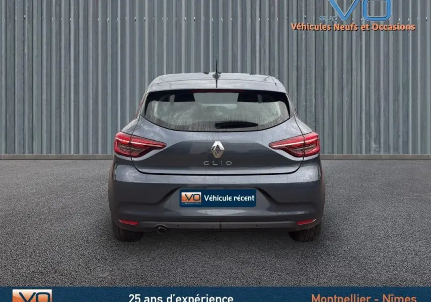 Vue arrière d'une Renault Clio V Blue dCi 85 Business gris foncé, avec feux arrière allumés et plaque "Véhicule récent".