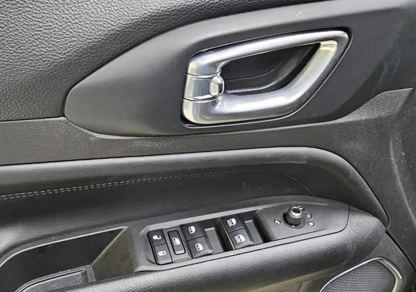 Poignée de porte intérieure côté gauche noire avec commandes électriques sur Jeep Compass 2023 hybride essence.