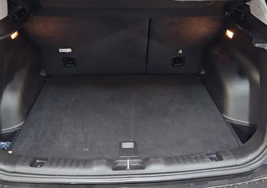 Coffre ouvert noir du Jeep Compass 2023, vue arrière montrant l'espace de chargement et l'éclairage intérieur.