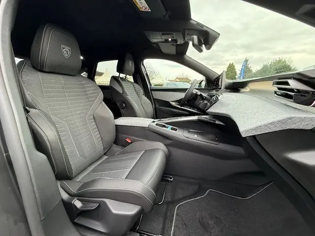 Vue intérieure côté conducteur du Peugeot 3008 Hybrid 145 GT avec sellerie tissus Uziris et inserts aluminium.
