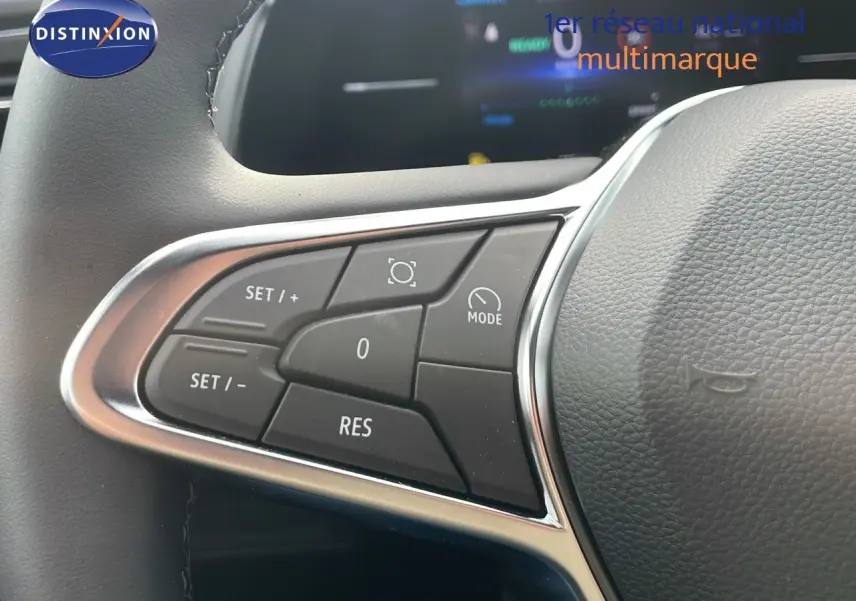 Gros plan sur les commandes du volant du Renault Captur E-Tech gris Cassiopée, mettant en valeur les boutons de régulateur de vitesse.