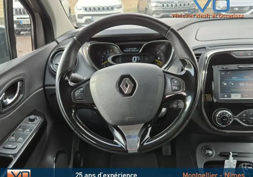 Vue intérieure centrée sur le volant cuir Renault Captur gris 2014 avec tableau de bord et écran tactile visible