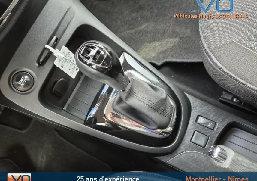 Gros plan sur la console centrale du Renault Captur gris 2014, mettant en valeur la boîte automatique et le bouton start/stop.