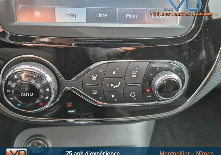 Gros plan sur la console centrale du Renault Captur gris 2014, mettant en valeur les commandes de climatisation automatique et l'écran tactile.