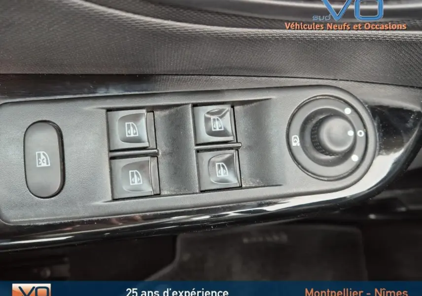 Gros plan sur les commandes électriques des vitres et rétroviseurs du côté gauche d'un Renault Captur gris 2014.