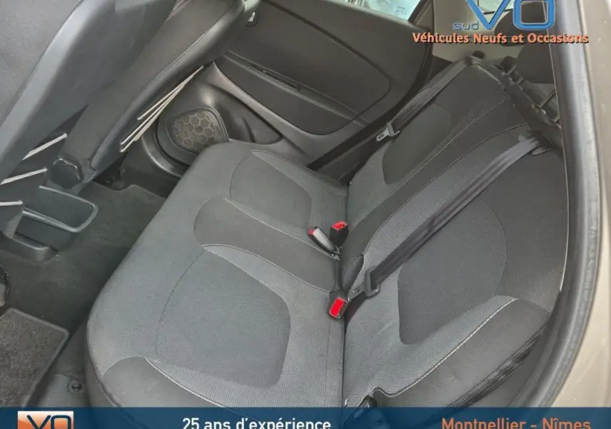 Vue intérieure sur les sièges arrière noirs du Renault Captur gris, avec ceintures de sécurité et appuis-tête visibles.