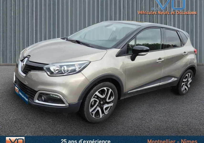 Renault Captur gris en 3/4 avant droit, jantes alliage 17 pouces et vitres surteintées visibles sur parking.