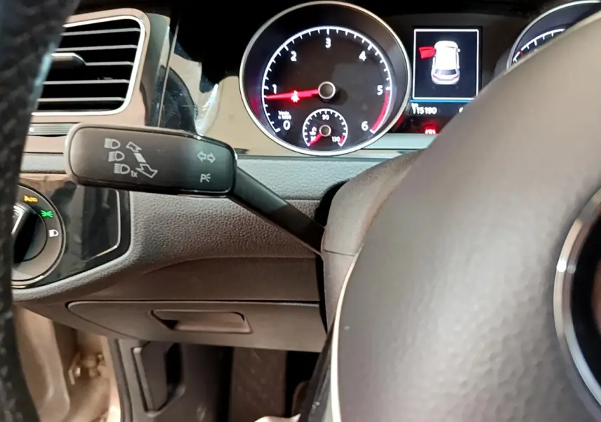 Vue rapprochée du tableau de bord de la Volkswagen Golf gris clair, avec compte-tours et indicateur d'ouverture de porte.