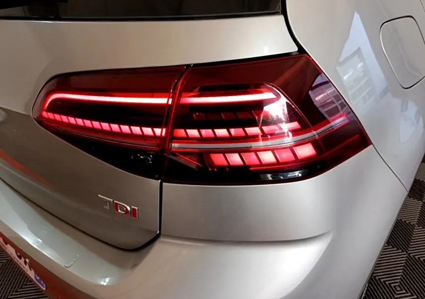 Gros plan sur le feu arrière droit rouge allumé d'une Volkswagen Golf gris clair diesel 2017.