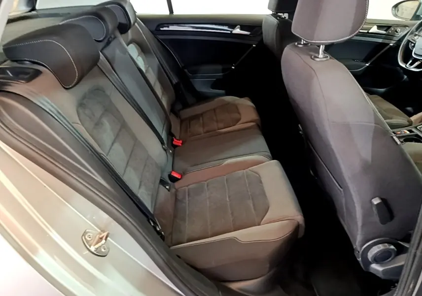 Vue intérieure côté gauche montrant la banquette arrière en tissu gris et partie avant du tableau de bord d'une Volkswagen Golf 2017.