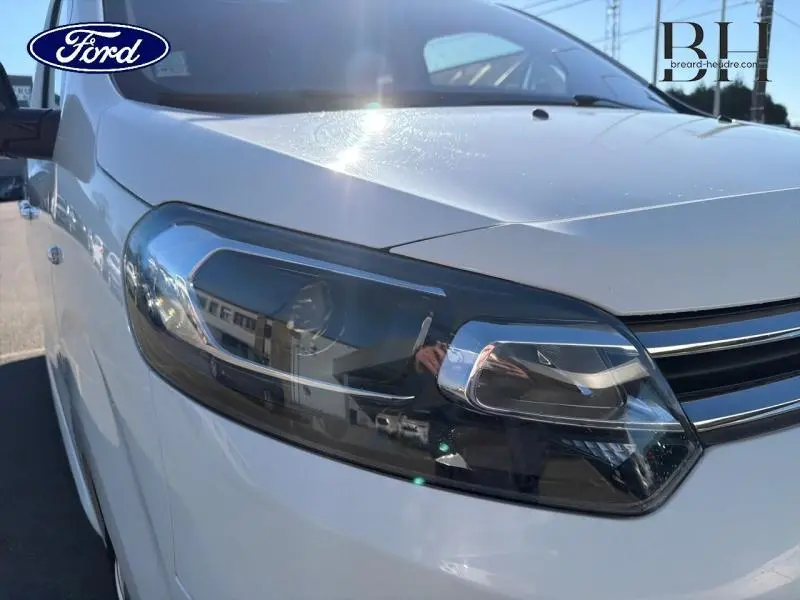 Gros plan sur le phare avant droit du Citroën Jumpy blanc Banquise, mettant en valeur son design moderne et épuré.
