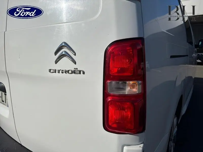 Gros plan sur l'arrière droit blanc banquise du Citroën Jumpy avec feux rouges et logo Citroën visible.