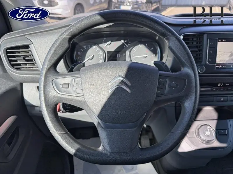 Vue rapprochée du volant Citroën Jumpy XL noir avec tableau de bord et écran tactile visibles en arrière-plan.