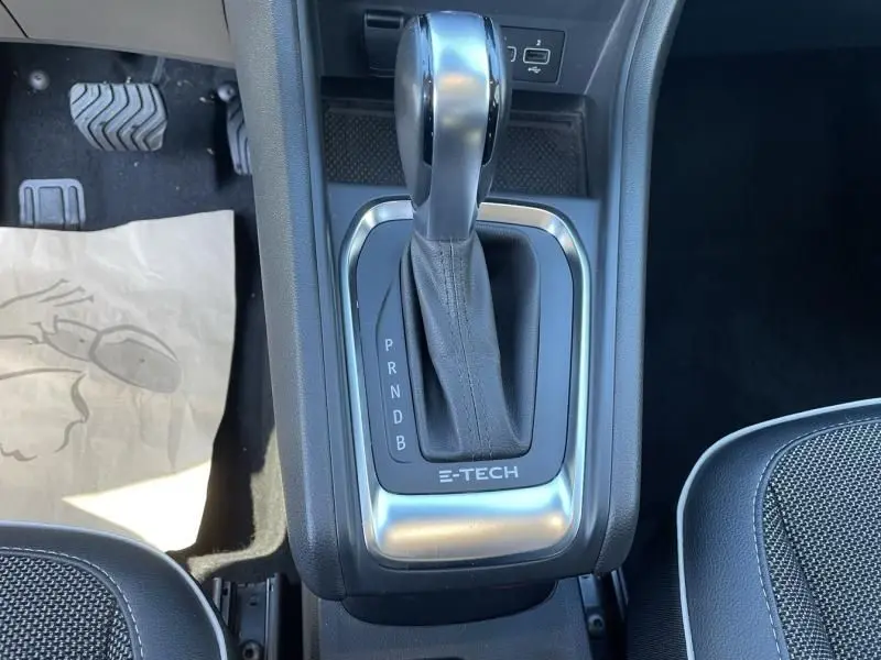 Le levier de vitesses automatique E-TECH du Renault Captur gris métal 2022 vu de dessus, avec console centrale et pédales.
