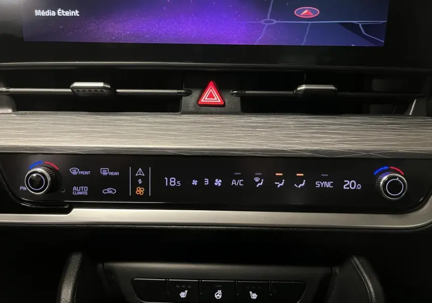 Tableau de bord du Kia Sportage 2022 montrant la commande de climatisation automatique avec affichage digital et réglages rotatifs.