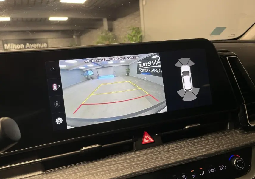 Écran tactile intérieur du Kia Sportage 2022 montrant la caméra de recul avec lignes de guidage en garage.