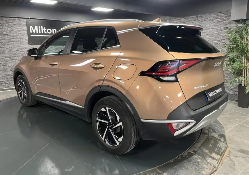 Vue 3/4 arrière droit d'un KIA SPORTAGE marron métallisé avec jantes alliage 17 pouces et feux arrière LED boomerang.