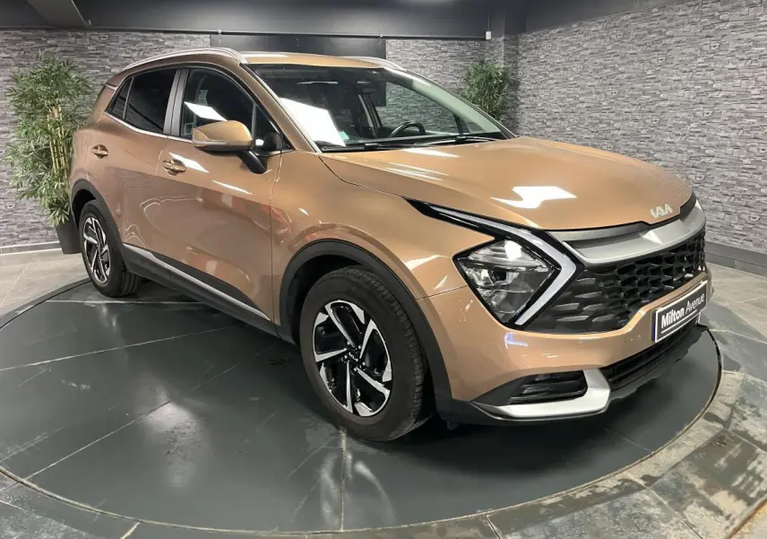 KIA SPORTAGE marron métallisé en 3/4 avant droit avec calandre noire laquée et jantes alliage 17 pouces.