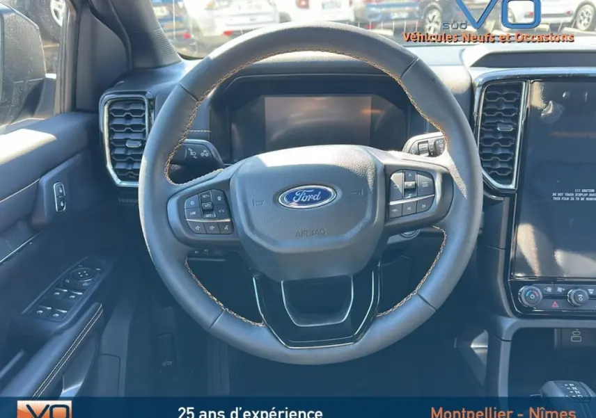 Vue centrée sur le volant multifonctions du Ford Ranger gris 2025 avec tableau de bord et écran tactile.