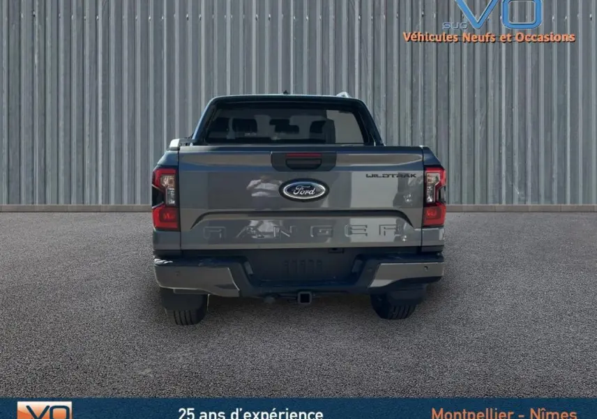 Vue arrière d'un Ford Ranger gris Wildtrak X 2025 avec hayon fermé et feux arrière allumés.
