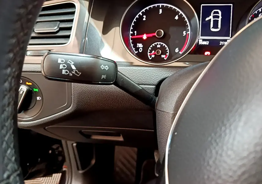 Gros plan sur le commodo gauche et le tableau de bord noir d'une Volkswagen Golf 2018, affichage digital et compte-tours visibles.