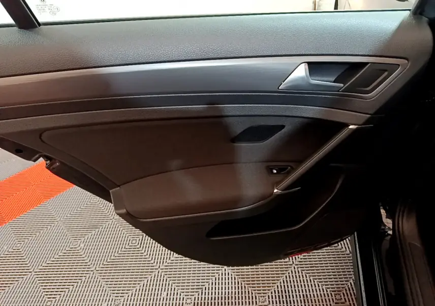 Vue intérieure du panneau de porte côté droit noir de la Volkswagen Golf 2018 avec poignée argentée et haut-parleur intégré