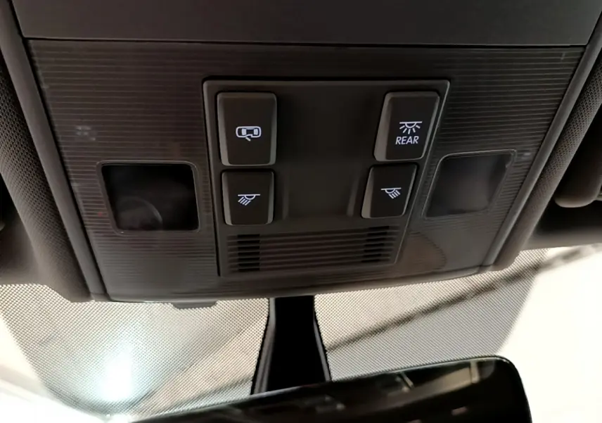Vue en contre-plongée du panneau de commandes d'éclairage intérieur noir de la Volkswagen Golf 2018, avec quatre boutons lumineux.