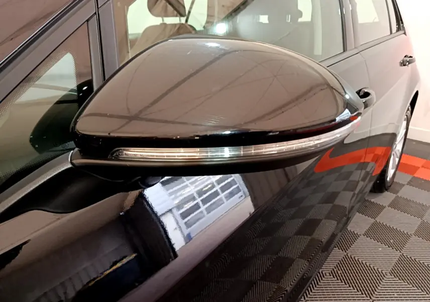 Rétroviseur droit noir brillant avec clignotant intégré sur Volkswagen Golf 1.6 TDI 2018 vue rapprochée côté passager.