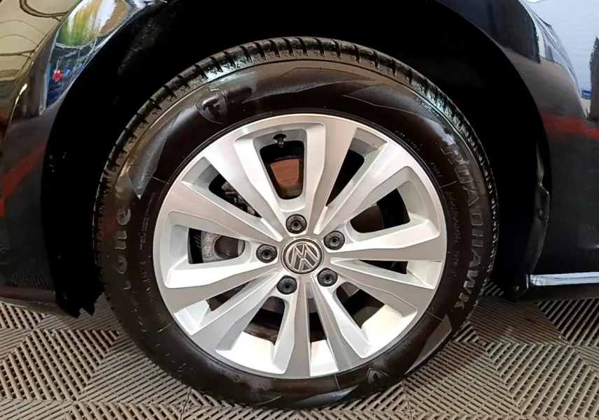 Gros plan sur la roue avant gauche d'une Volkswagen Golf noire de 2018 avec jante alliage à 10 branches.