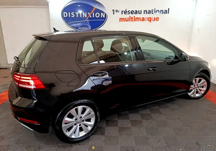 Volkswagen Golf noire 2018 vue de profil côté gauche, feux arrière allumés et jantes alliage visibles.