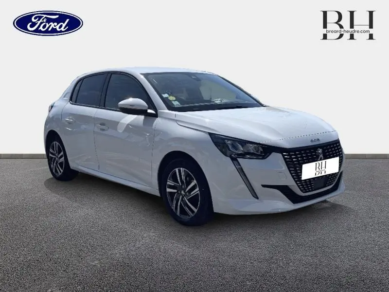 Peugeot 208 blanc banquise vue 3/4 avant droit, avec calandre noire et jantes alliage distinctives.