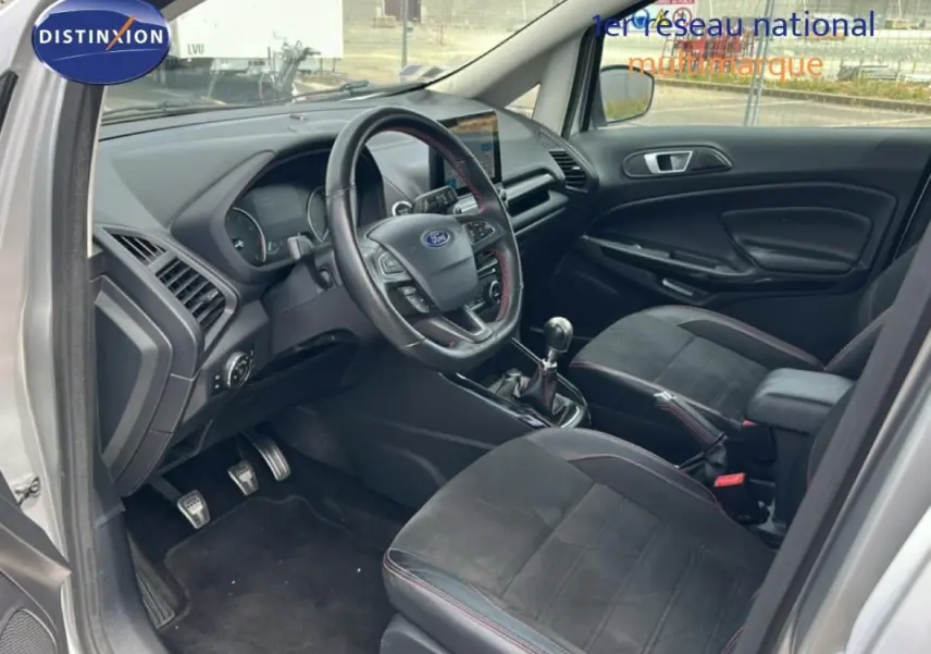 Vue intérieure côté conducteur du Ford EcoSport gris clair 2018, avec volant multifonction et boîte manuelle.