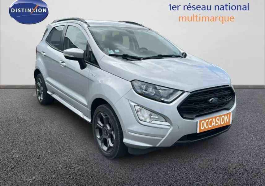 Ford EcoSport gris clair en 3/4 avant droit avec jantes alliage et barres de toit visibles sur fond neutre.