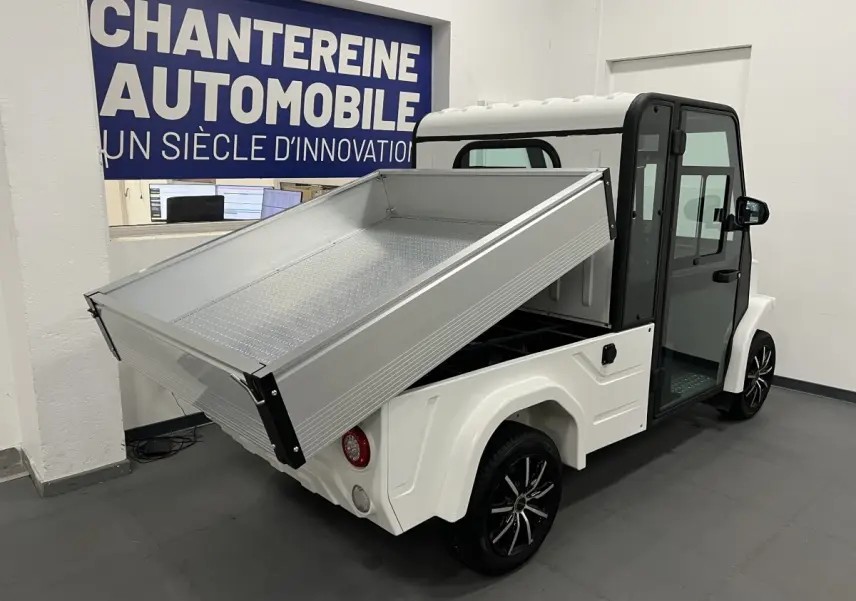 Vue 3/4 arrière droite du Liberty L7E H2 160 blanc avec kit ridelles relevé et jantes alliage 13 pouces noires.