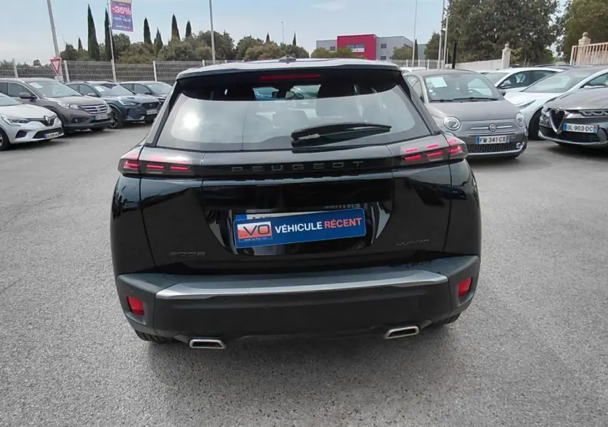 Vue arrière d’un Peugeot 2008 Hybrid 145 noir 2025 avec feux LED caractéristiques et double sortie d’échappement.