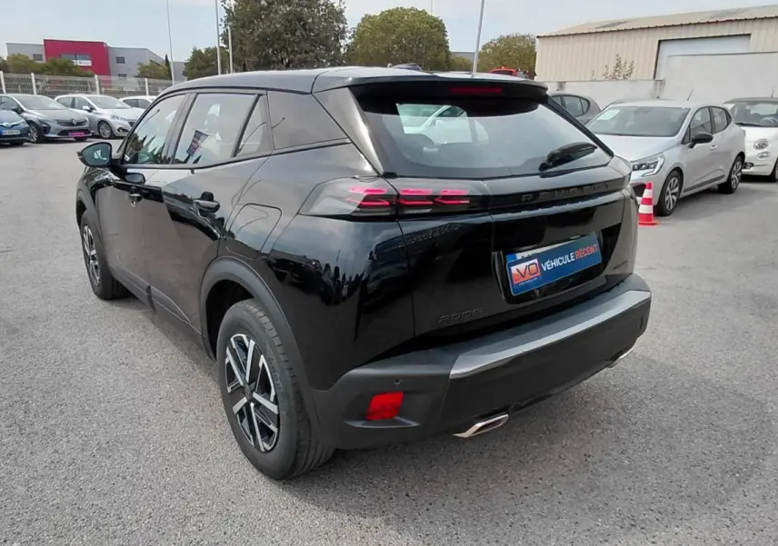 Vue 3/4 arrière droite d’un Peugeot 2008 Hybrid 145 noir, avec feux arrière à effet griffes et jantes alliage.