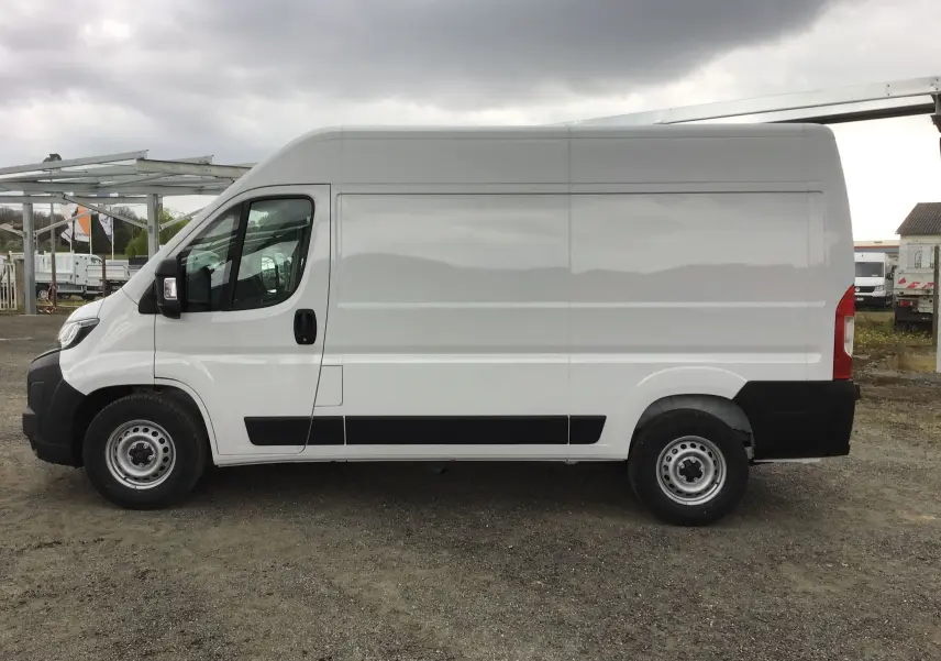 Profil côté gauche d'un utilitaire blanc Peugeot Boxer Fourgon L2H2 2025 avec porte latérale et jantes acier.