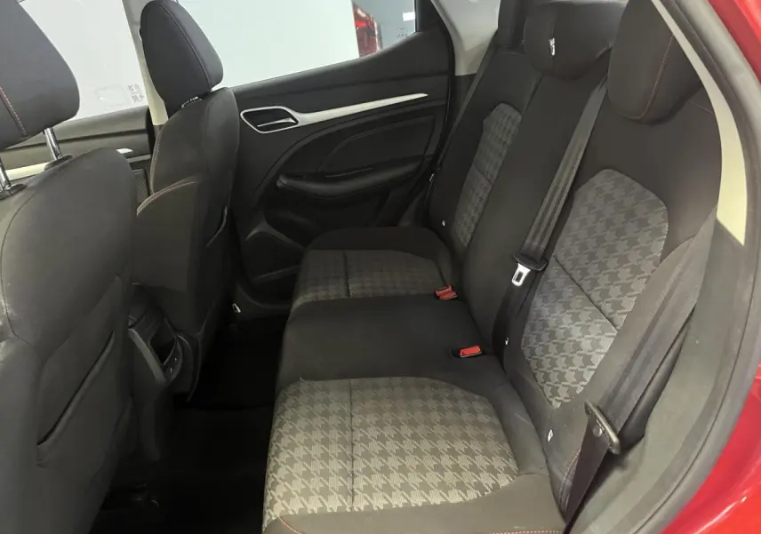 Vue intérieure côté droit sur la banquette arrière en tissu gris à motifs, avec portières rouges visibles sur MG ZS 2022.