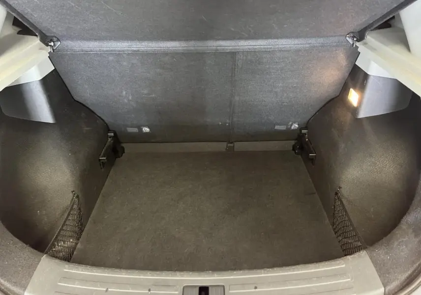 Coffre vide vu de l'arrière d'un MG ZS rouge 2022, avec éclairage intérieur et filets latéraux de rangement.