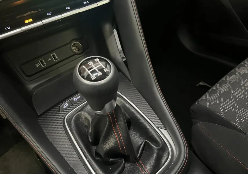 Gros plan sur le levier de vitesses manuel du MG ZS 2022 avec coutures rouges et console à effet carbone.