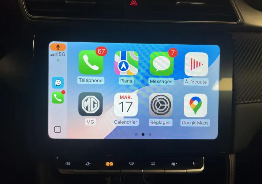Écran tactile central de la MG ZS 2022 affichant Apple CarPlay avec icônes colorées et commandes en dessous.